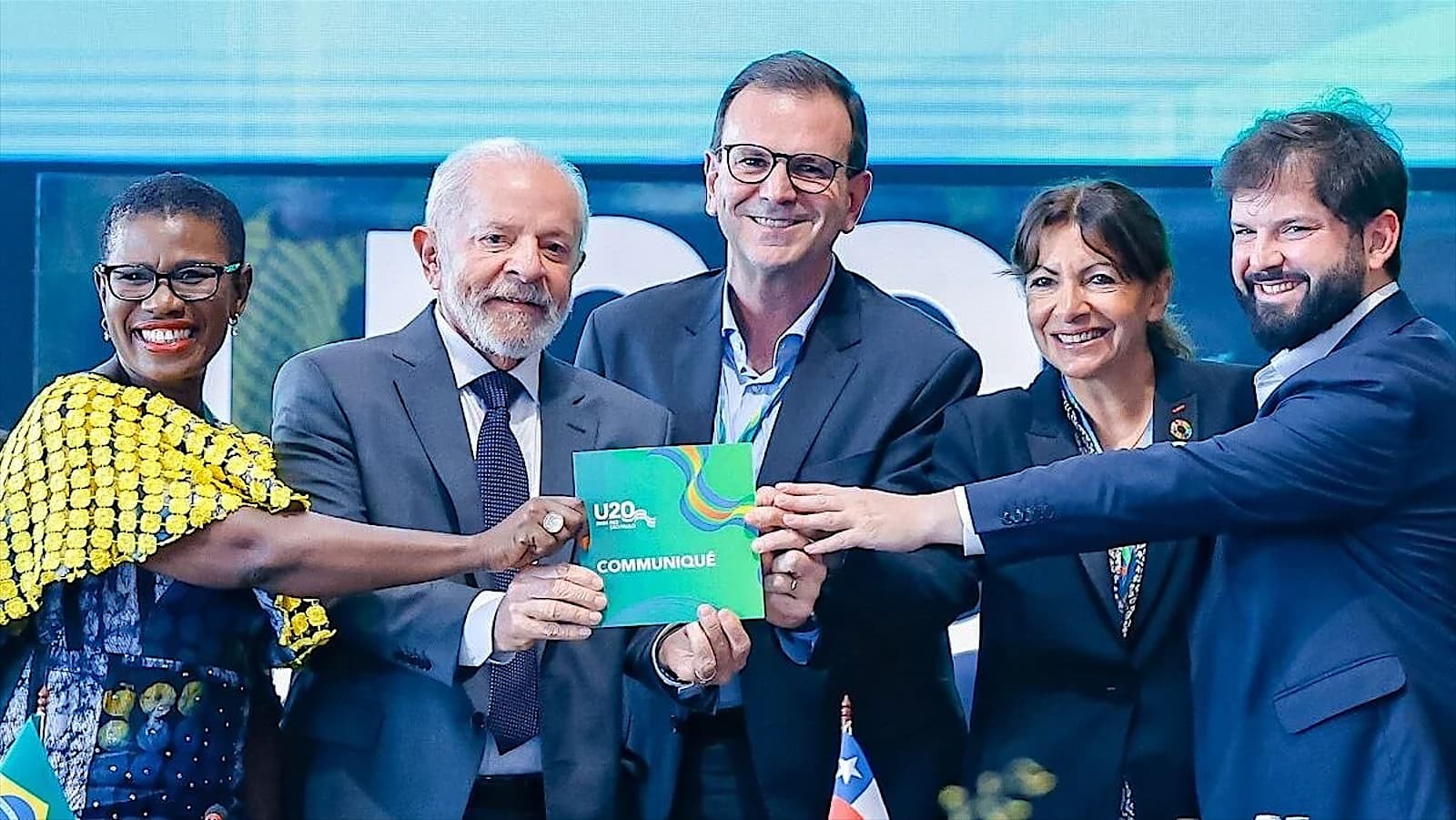 Partners presenting a publication on stage at an international summit