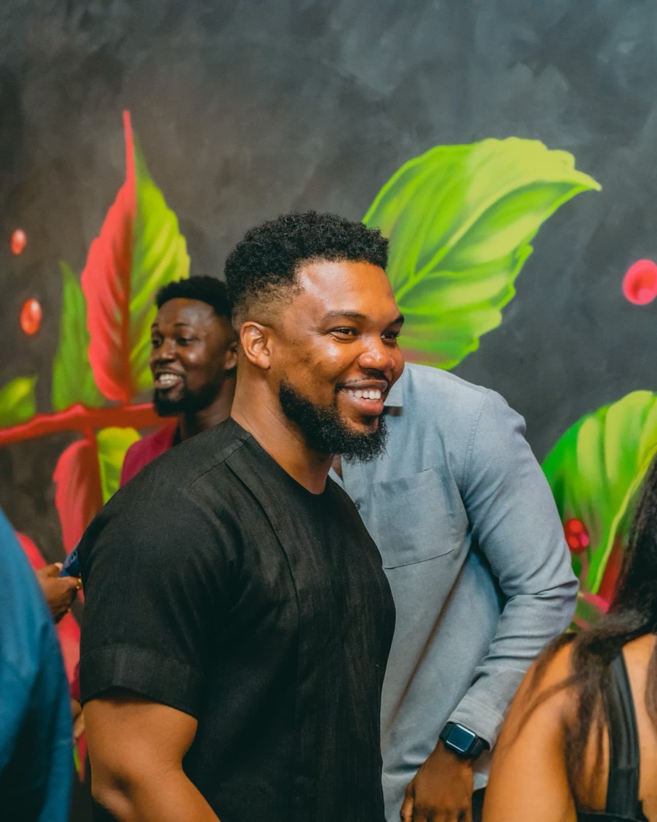 Sydney Scott Sam, CEO and Co-founder of Workspace Global, laughing with guests in front of a painted mural
