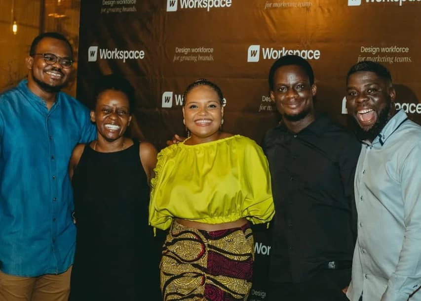 Five people smiling in front of the Workspace backdrop