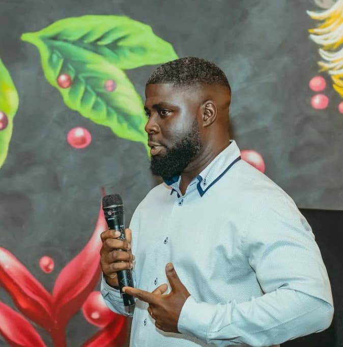 A speaker with a microphone in front of a painted mural