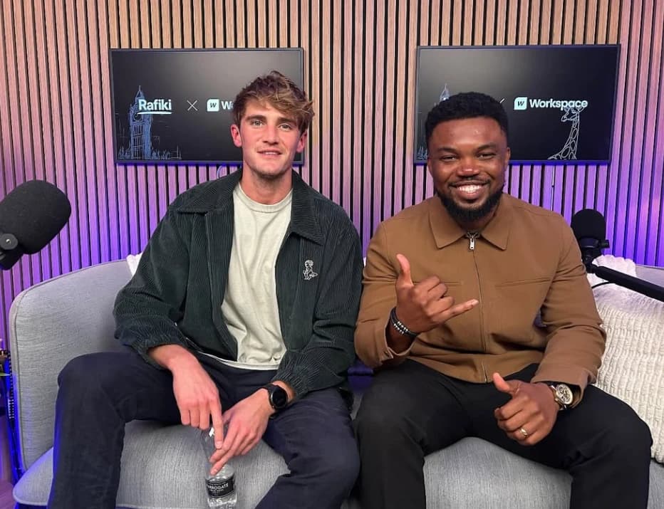 Two people smiling on a sofa in a podcast studio, Rafiki and Workspace logos on the screens behind them