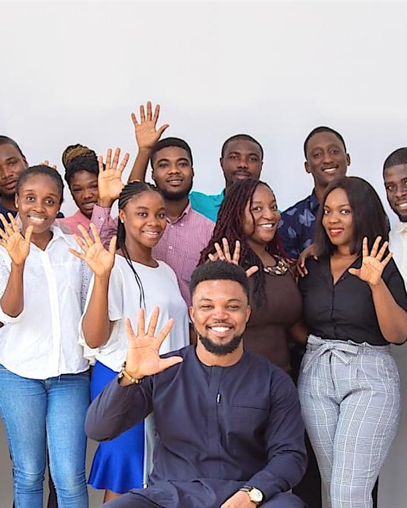 Workspace creatives together, smiling and waving