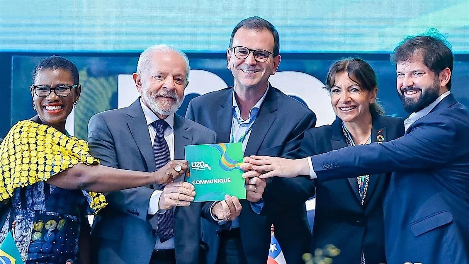 Partners presenting a publication on stage at an international summit