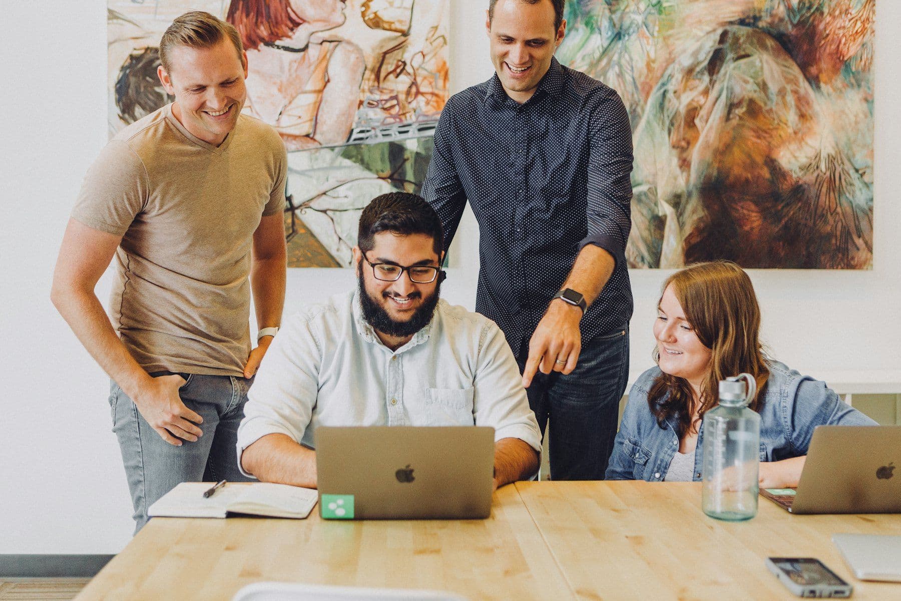 An agency team gathered around a laptop in a bright studio