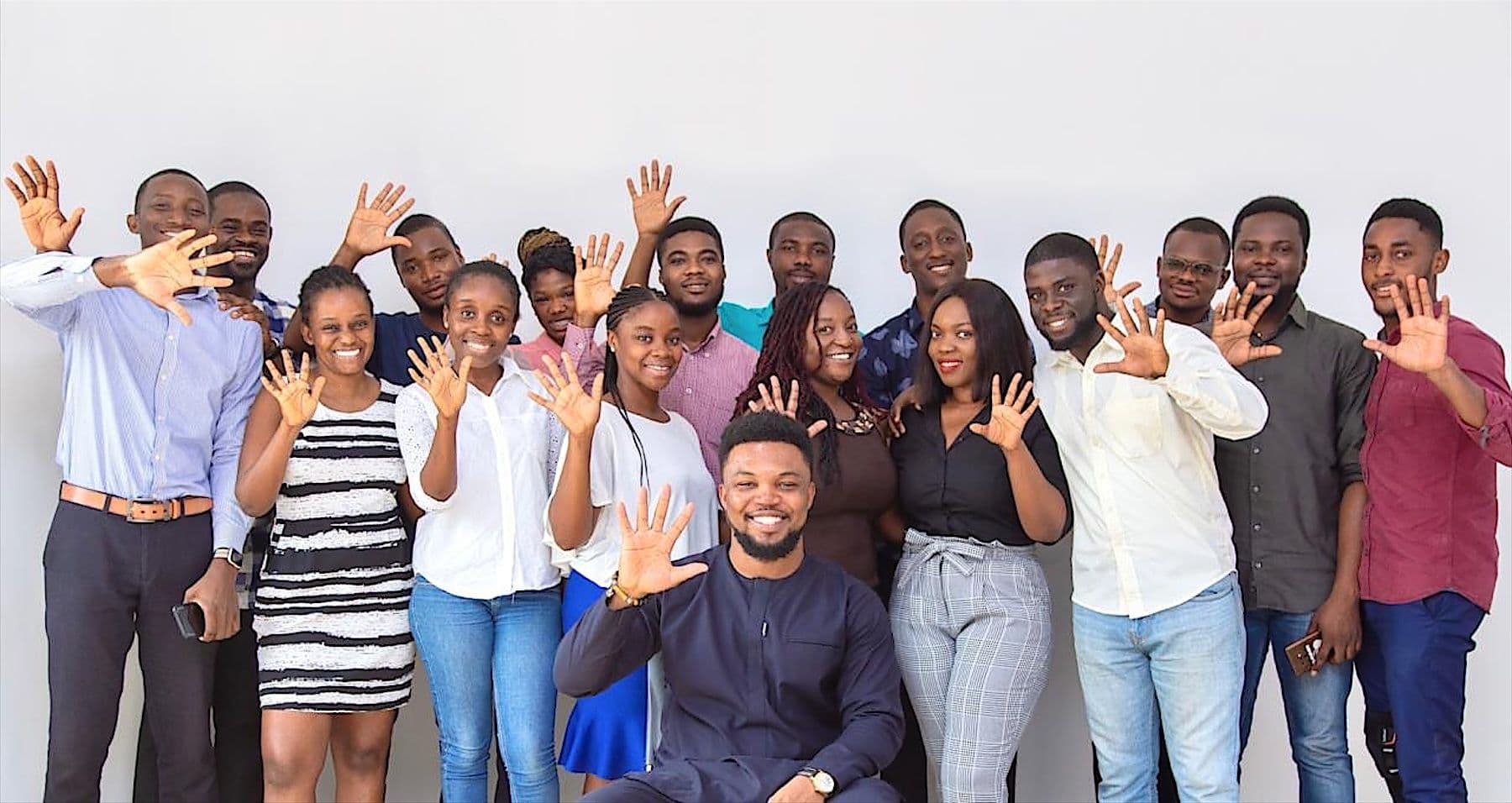 A growing group of Workspace creatives smiling and waving at the camera