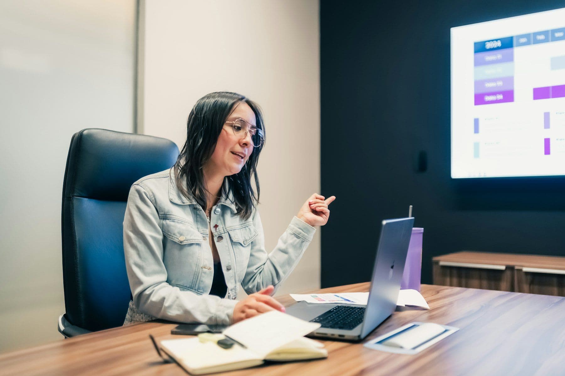A marketer presenting a slide of results from her laptop in a meeting room